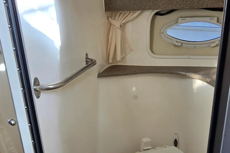 Slide: The Image of 2007 Rinker 320 Express Cruiser bathroom interior with porthole and handrail. - 35
