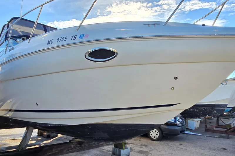Slide: The Image of 2007 Rinker 320 Express Cruiser boat on dry dock under a clear sky. - 4