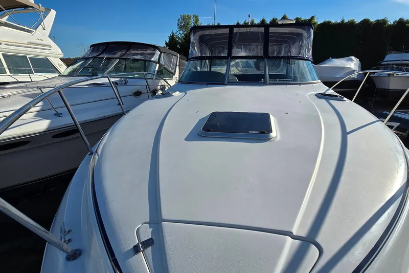 Slide: The Image of 2007 Rinker 320 Express Cruiser boat docked, showcasing sleek design and spacious deck. - 5