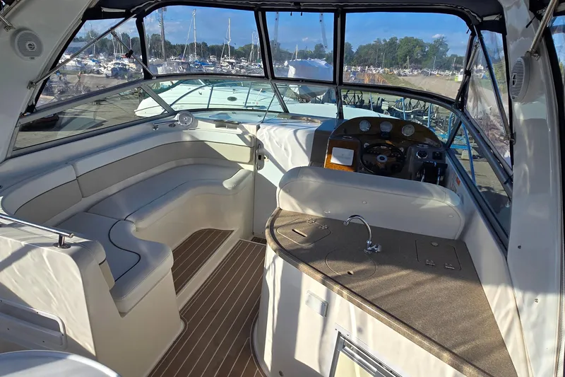 Slide: The Image of 2007 Rinker 320 Express Cruiser interior with seating, helm, and kitchenette. - 6