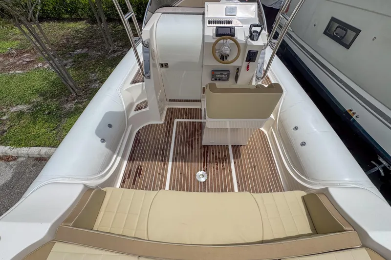 Slide: The Image of 2023 Tender Impertus 36 boat interior with beige seating and wooden flooring. - 18