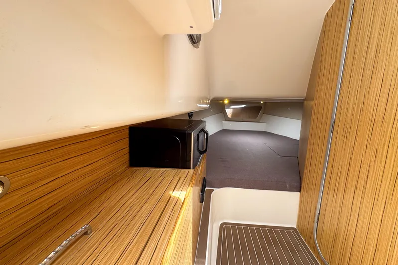 Slide: The Image of Interior of 2023 Tender Impertus 36 boat with wood finish and compact kitchen area. - 24