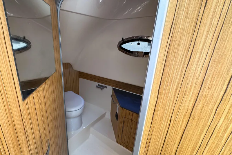 Slide: The Image of 2023 Tender Impertus 36 boat interior with wooden finish and compact bathroom. - 28