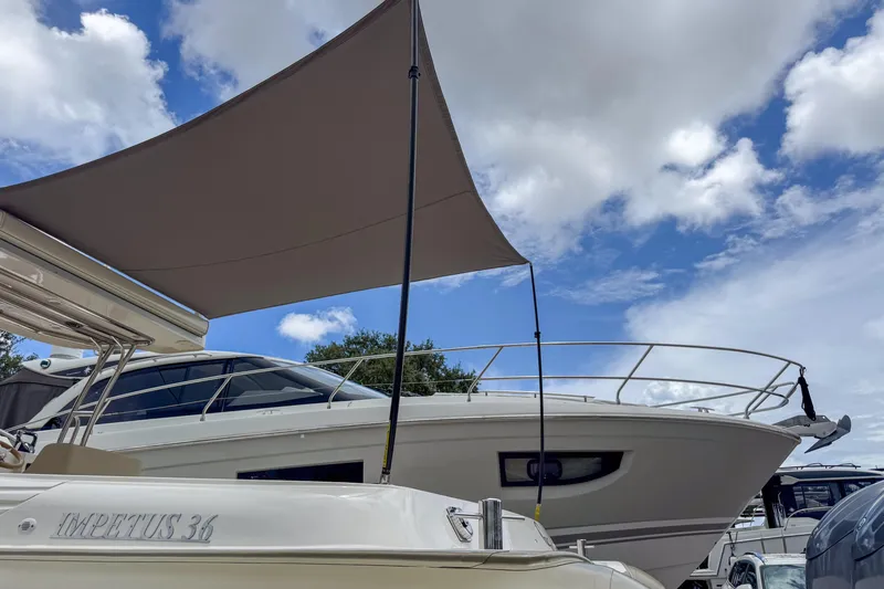 Slide: The Image of 2023 Tender Impertus 36 yacht under a sunshade, with a cloudy sky backdrop. - 46