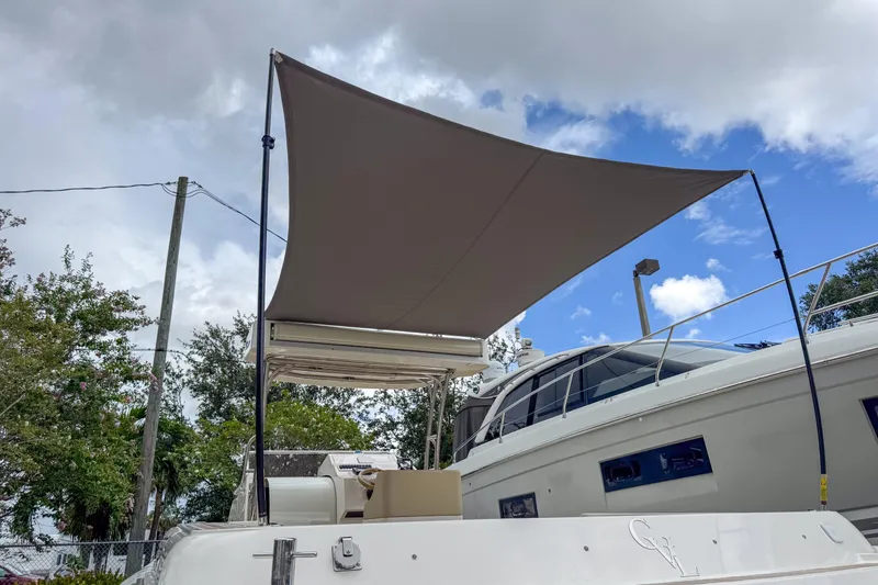 Slide: The Image of 2023 Tender Impertus 36 yacht with sunshade, docked under cloudy sky. - 48