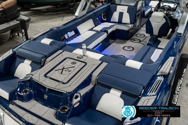 Slide: The Image of 2025 MasterCraft X24 boat interior with blue and white seating, modern design, and spacious layout. - 14