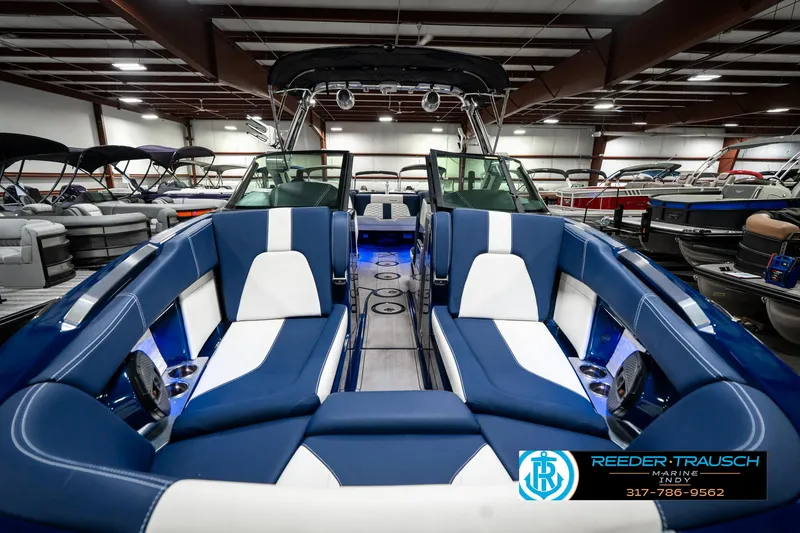 Slide: The Image of 2025 MasterCraft X24 boat interior with blue and white seating in a showroom. - 22