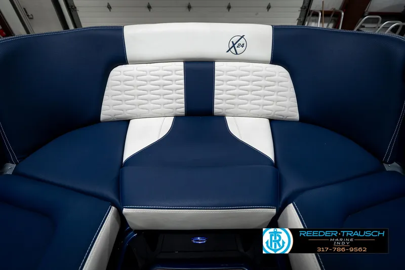 Slide: The Image of 2025 MasterCraft X24 boat interior with blue and white seating, featuring modern design elements. - 24