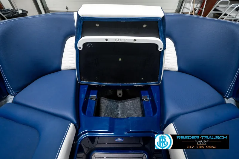 Slide: The Image of 2025 MasterCraft X24 boat interior with blue seating and storage compartment. - 25
