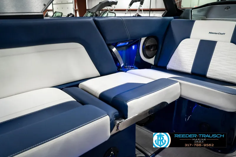 Slide: The Image of 2025 MasterCraft X24 boat interior with blue and white seating, featuring modern design elements. - 28