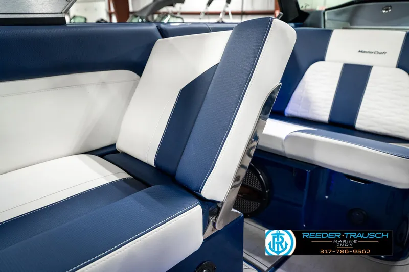 Slide: The Image of 2025 MasterCraft X24 boat interior with blue and white seating, featuring Reeder-Trausch Marine branding. - 29