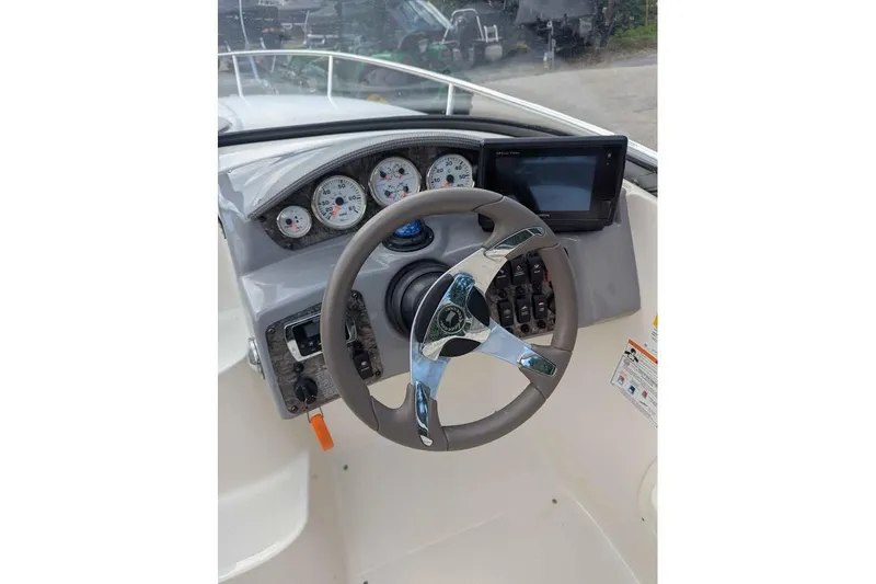 Slide: The Image of Steering wheel and dashboard of 2013 Stingray 225cr boat, featuring gauges and controls. - 10