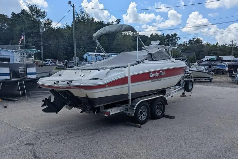 Slide: The Image of 2013 Stingray 225cr boat on trailer, covered and parked outdoors. - 2