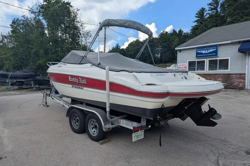 Slide: The Image of 2013 Stingray 225cr boat on trailer, covered and parked outdoors. - 4