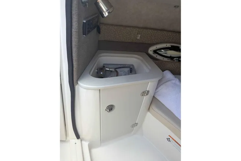 Slide: The Image of 2013 Stingray 225cr boat interior with compact sink and storage cabinet. - 7