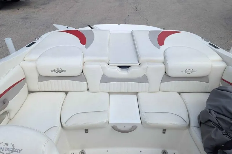 Slide: The Image of 2013 Stingray 225cr boat interior with white and gray seating, red accents. - 9