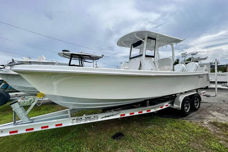 The Image of 2026 Pair Customs 27 Center Console boat on calm water, with scenic background. - 0