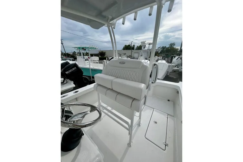 Slide: The Image of 2026 Pair Customs 27 Center Console boat with rod holders and seating, docked outdoors. - 14