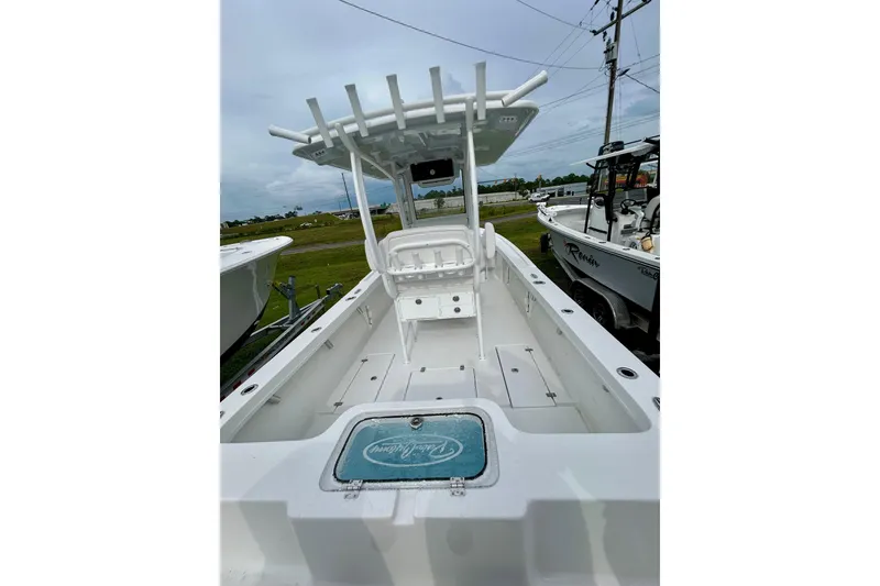 Slide: The Image of 2026 Pair Customs 27 Center Console boat on calm water, with scenic shoreline background. - 2