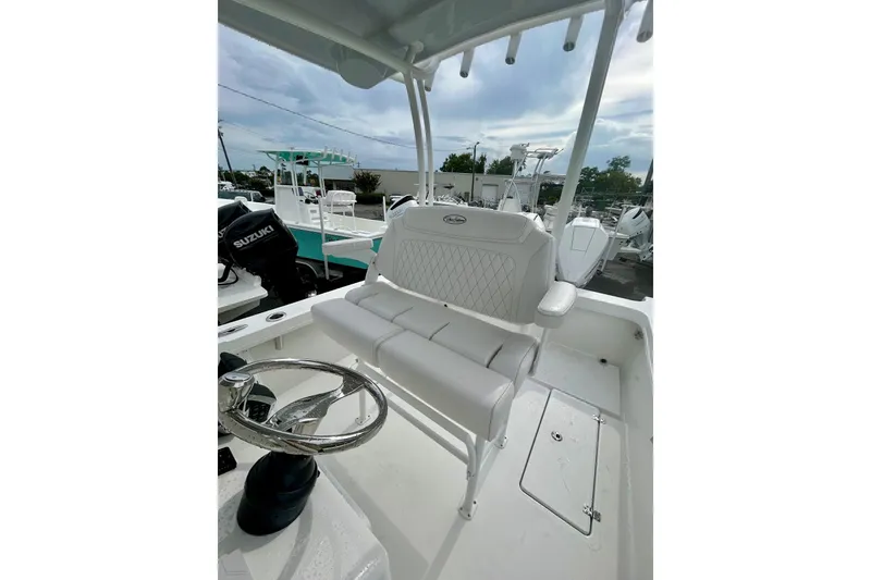 Slide: The Image of 2026 Pair Customs 27 Center Console boat interior with white seating and steering wheel. - 27