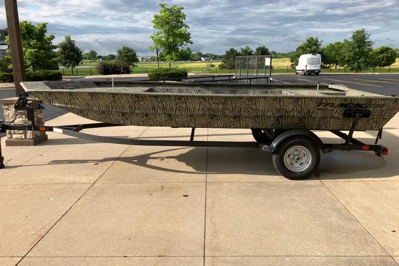 The Image of 2026 Tracker Grizzly 1860 Utility boat on trailer, parked outdoors. - 0