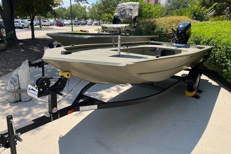 The Image of 2026 Tracker Grizzly 1654 T Sportsman boat on trailer, parked outdoors. - 0