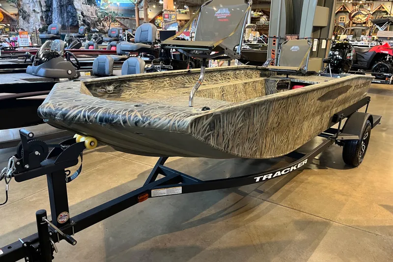 Slide: The Image of 2026 Tracker Grizzly 1654 T Sportsman boat with camouflage design on display in showroom. - 42