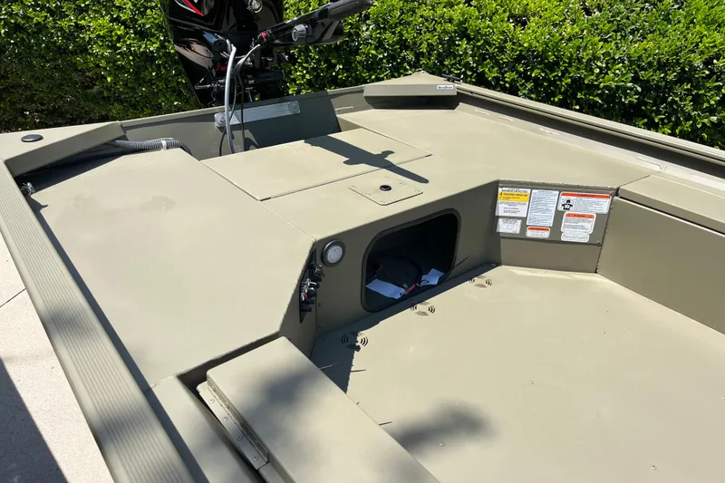 Slide: The Image of 2026 Tracker Grizzly 1654 T Sportsman boat interior with storage compartment and motor. - 5