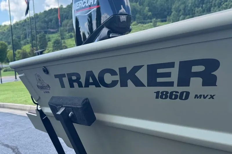 Slide: The Image of 2026 Tracker Grizzly 1860 CC boat with Mercury engine, parked outdoors. - 4