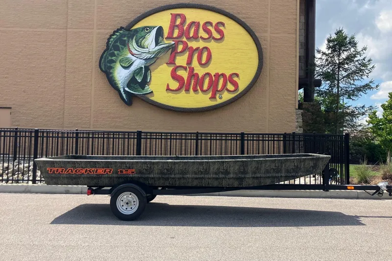 The Image of 2026 Tracker Grizzly 15 Jon boat outside Bass Pro Shops store. - 0