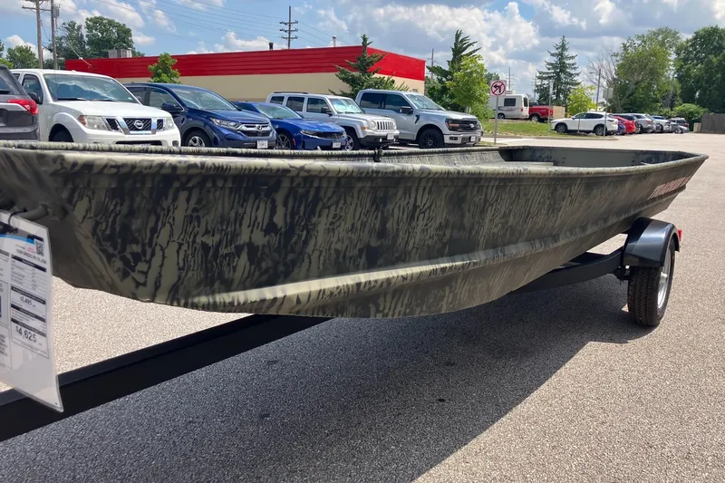 Slide: The Image of 2026 Tracker Grizzly 15 Jon boat on trailer, parked in a lot with cars. - 5