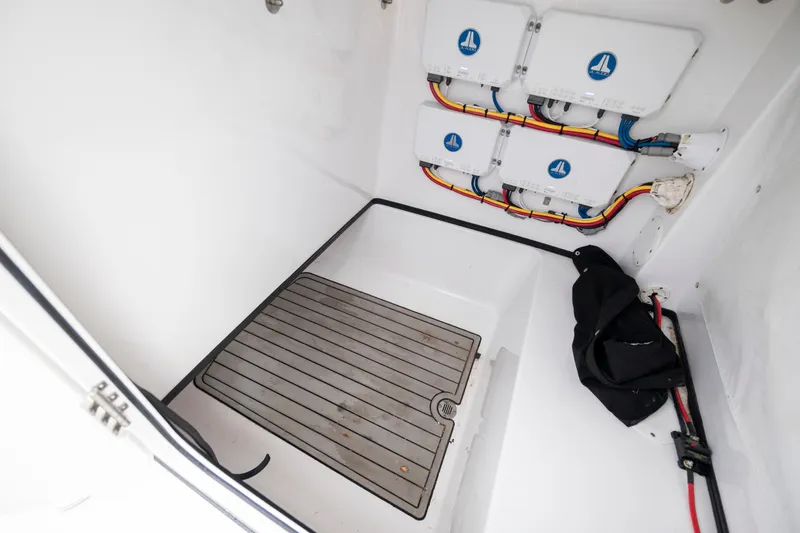 Slide: The Image of 2020 Sportsman Masters 267OE Bay Boat interior wiring compartment with organized cables and equipment. - 22