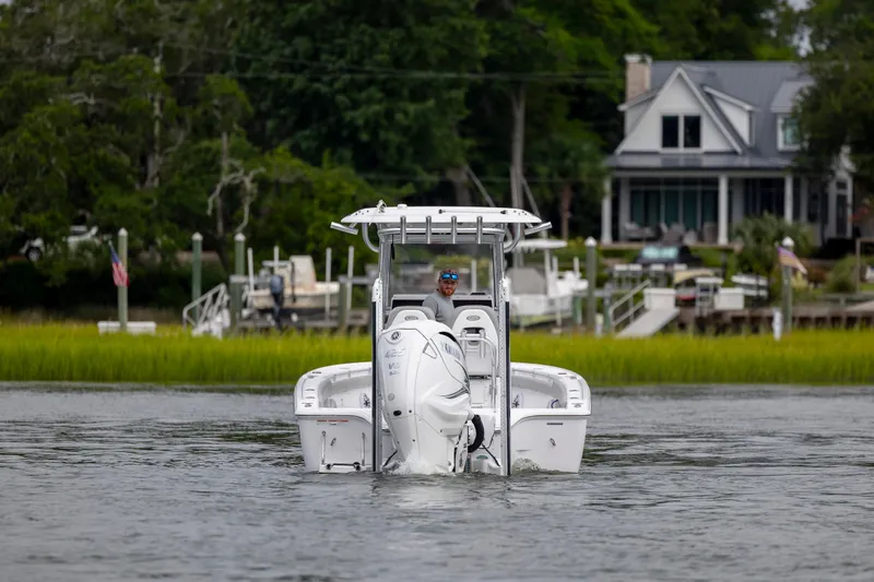 Slide: The Image of 2020 Sportsman Masters 267OE Bay Boat cruising near a waterfront home. - 4