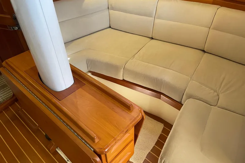 Slide: The Image of Interior of 2004 Tartan 3700 sailboat with beige cushioned seating and wooden accents. - 16