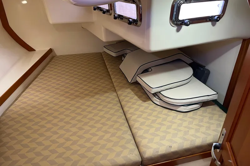Slide: The Image of Interior cabin of a 2004 Tartan 3700 sailboat with patterned cushions and storage. - 17
