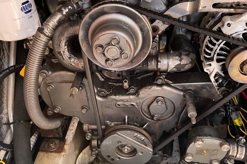 Slide: The Image of Engine components of a 2004 Tartan 3700, featuring belts and hoses in close-up view. - 18