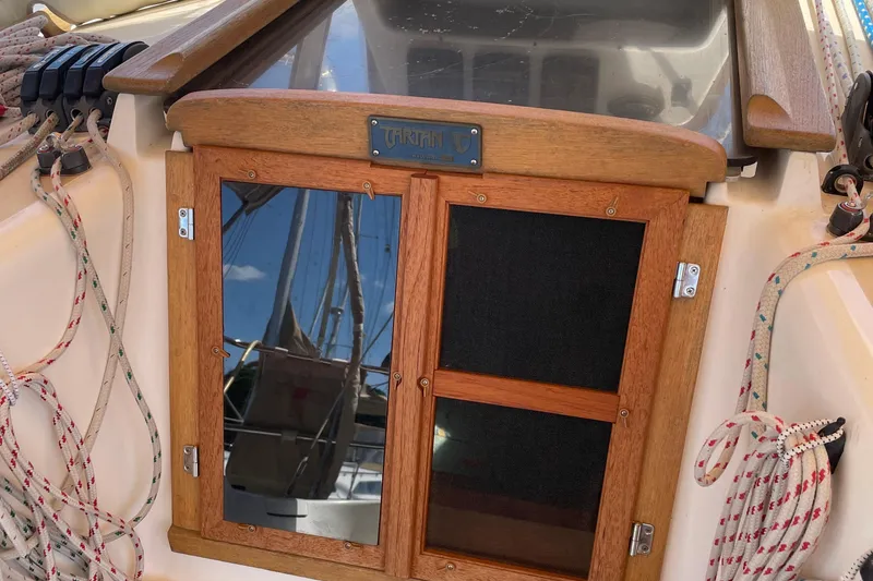 Slide: The Image of Wooden hatch of a 2004 Tartan 3700 sailboat with ropes and reflections. - 2