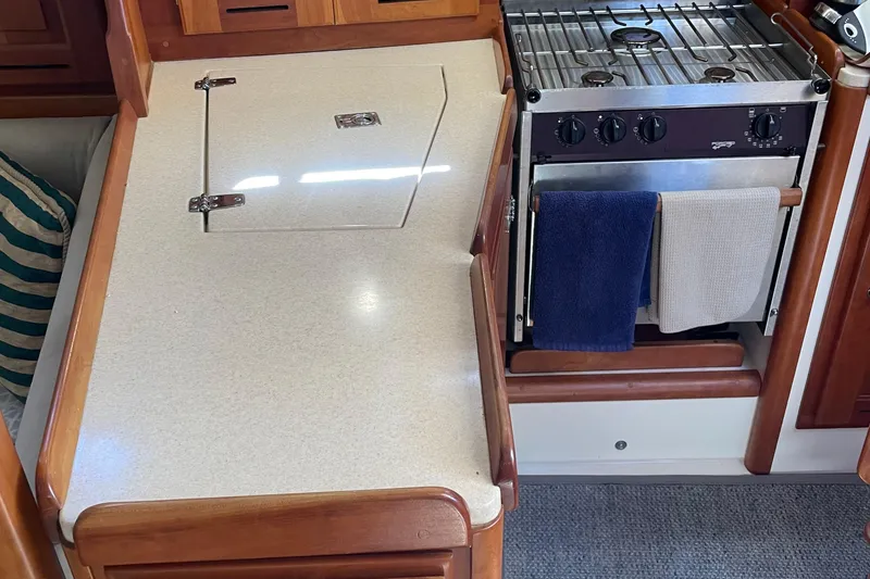 Slide: The Image of 2004 Tartan 3700 yacht kitchen with stove, countertop, and towels. - 22