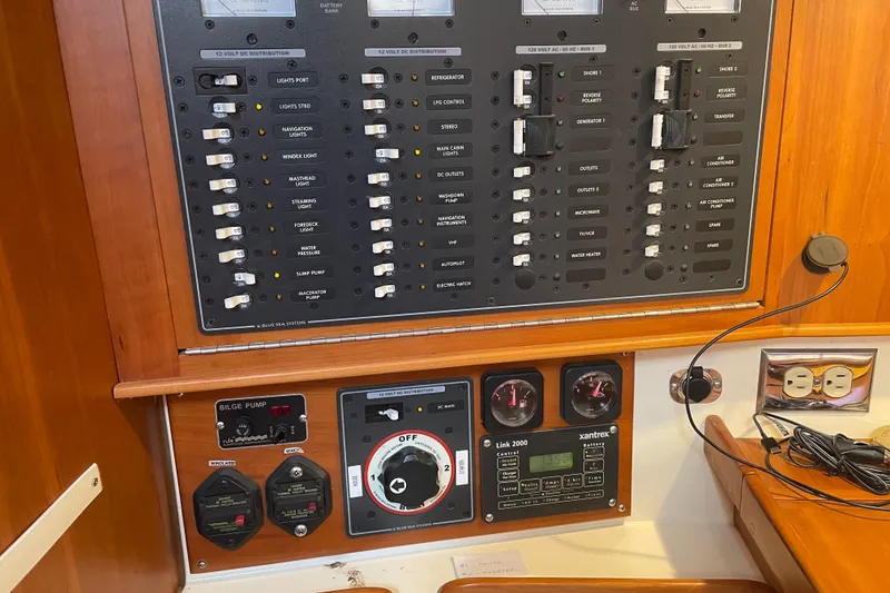 Slide: The Image of Electrical control panel on a 2004 Tartan 3700 yacht, featuring various switches and gauges. - 26