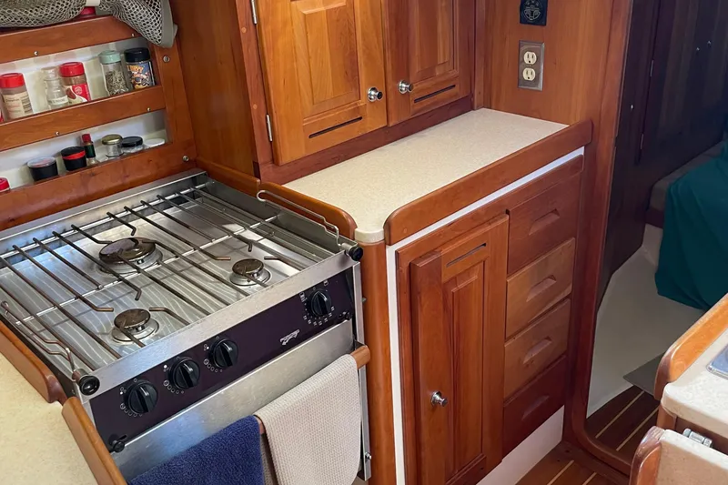 Slide: The Image of Wooden yacht kitchen with stove, spice rack, and cabinetry in a 2004 Tartan 3700. - 31