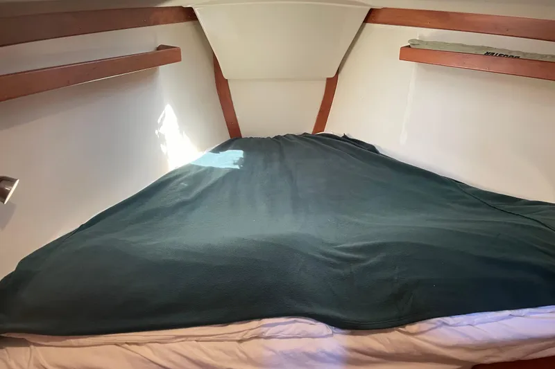Slide: The Image of Cozy cabin interior of 2004 Tartan 3700 sailboat with green blanket on bed. - 32