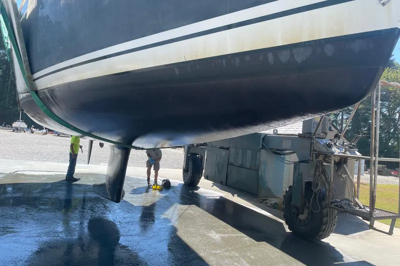 Slide: The Image of Tartan 3700 sailboat from 2004 being serviced on a lift at a boatyard. - 36