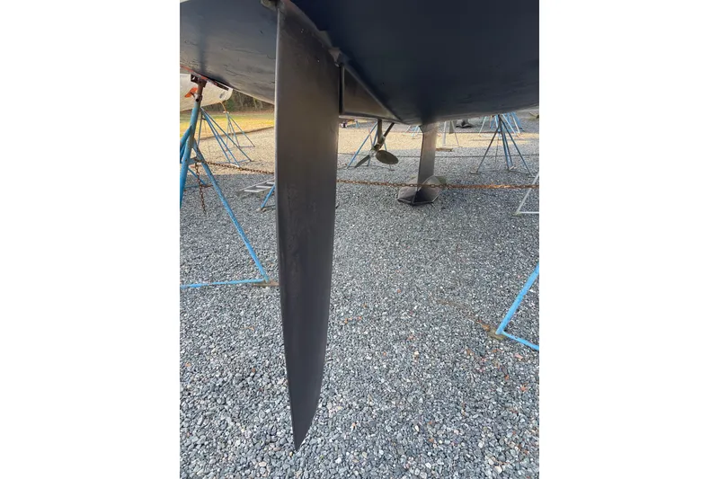 Slide: The Image of Keel of 2004 Tartan 3700 sailboat on gravel with blue supports. - 45