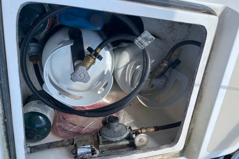 Slide: The Image of Propane storage compartment on a 2004 Tartan 3700 sailboat, featuring tanks and hoses. - 8
