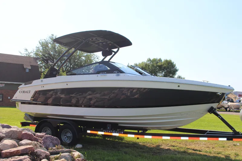 The Image of 2025 Cobalt R4 Surf boat on trailer, parked on grass, sunny day. - 10