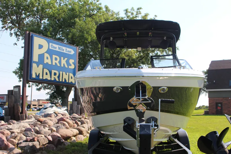 Slide: The Image of 2025 Cobalt R4 Surf boat at Parks Marina, surrounded by rocks and greenery. - 13