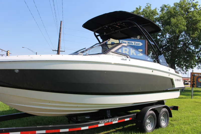 Slide: The Image of 2025 Cobalt R4 Surf boat on trailer, parked outdoors under clear sky. - 14
