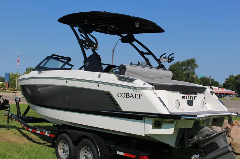 Slide: The Image of 2025 Cobalt R4 Surf boat on trailer, sleek design, black and white exterior. - 17