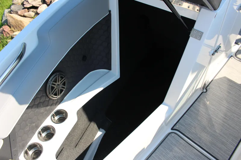 Slide: The Image of Interior view of 2025 Cobalt R4 Surf boat, featuring cup holders and speaker. - 32