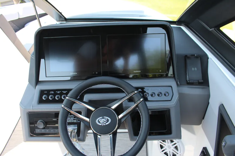 Slide: The Image of 2025 Cobalt R4 Surf boat dashboard with dual Garmin displays and modern steering wheel. - 35